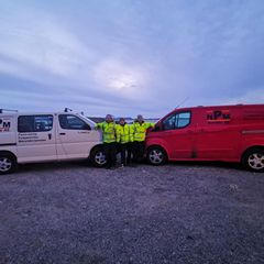 3 ansatte ved deres varebiler